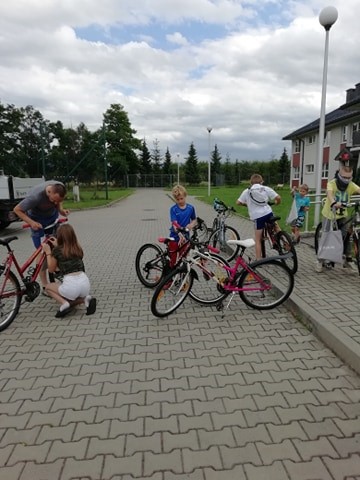 Pan Michał dopasowuje rowery do wzrostu dzieciaków